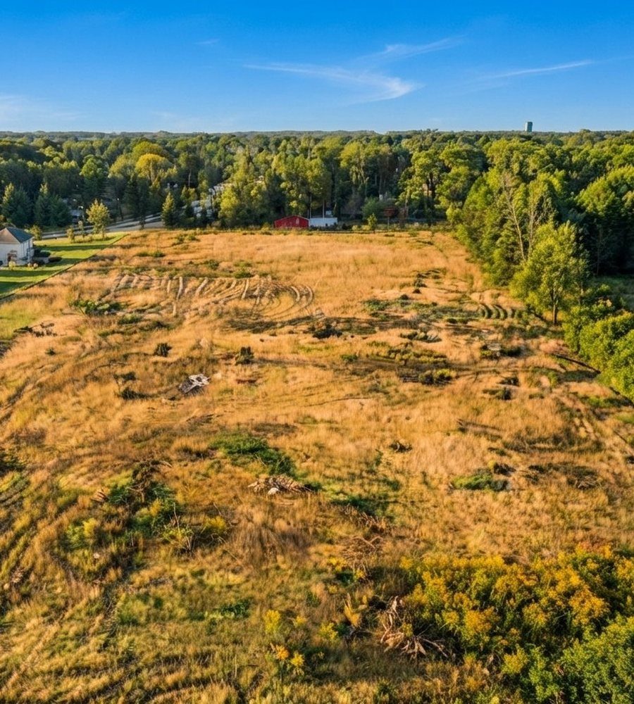 Aerial view of land next to a neighborhood