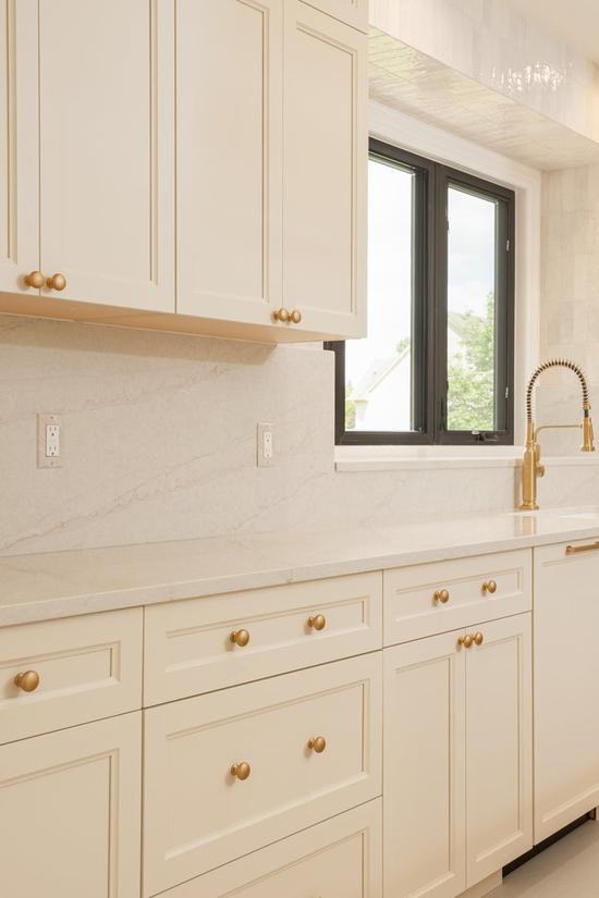 Bright white kitchen with a large island and gold hardware